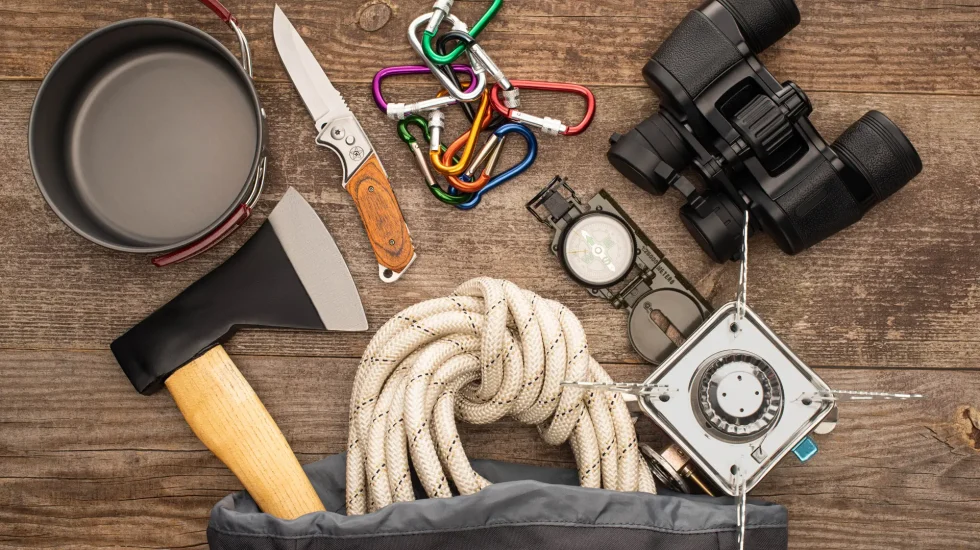 top-view-hiking-rope-axe-binoculars-knife-carabiners-compass-iron-mug-gas-burner