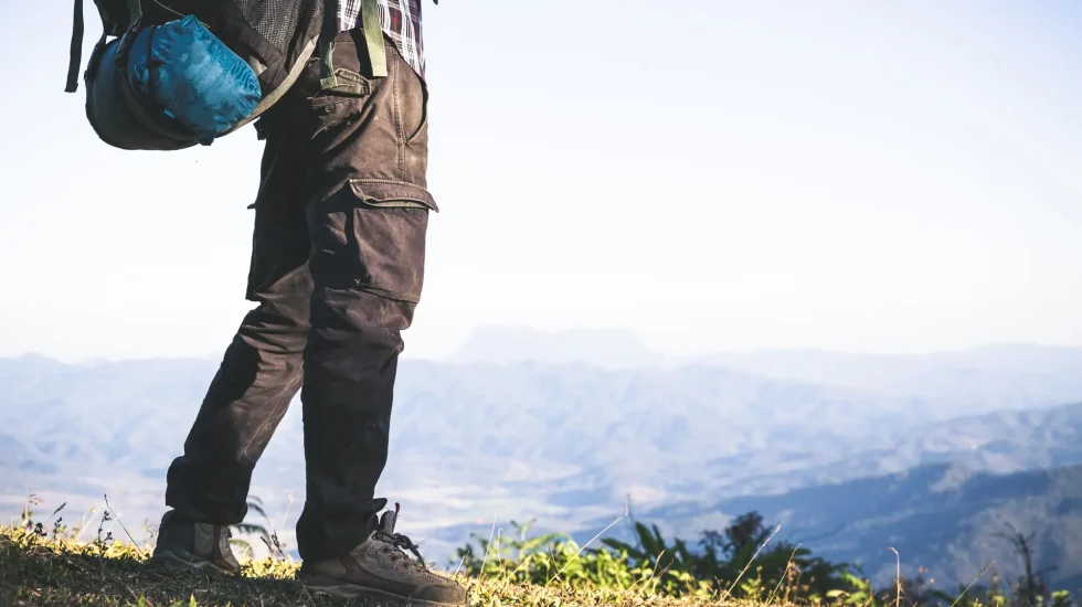 tourist-from-mountain-top-sun-rays-man-wear-big-backpack-against-sun-light